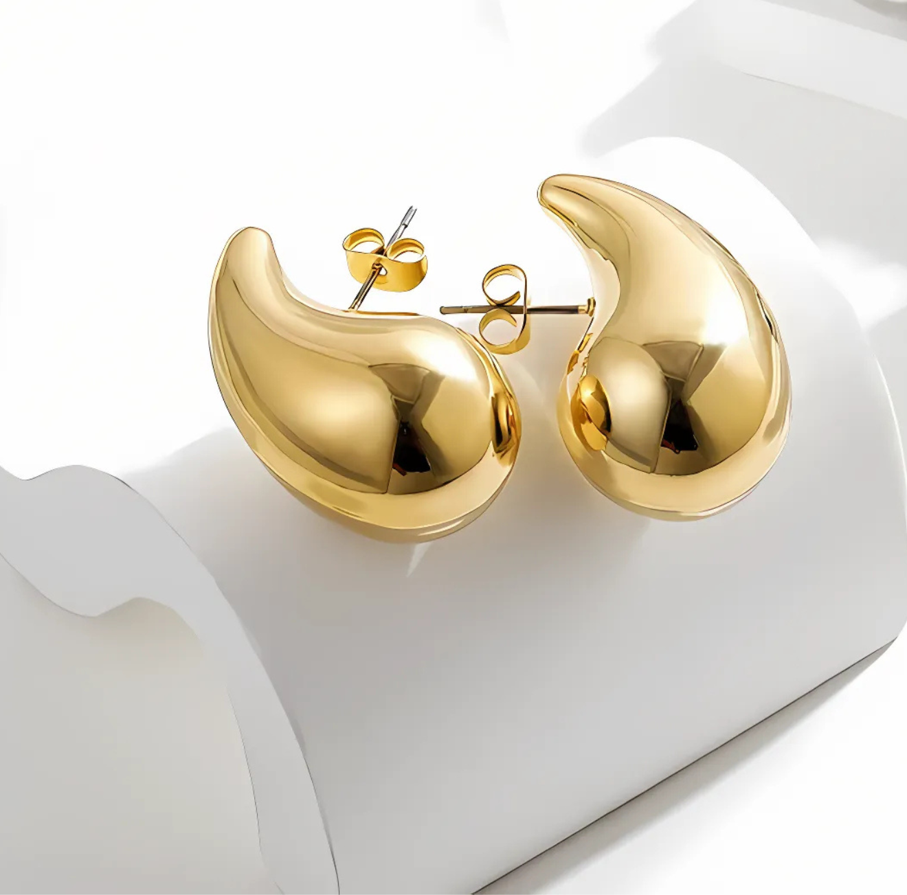 The Infinite Shop gold polished teardrop stud earrings displayed on a white background, featuring smooth curved design for a chic minimalist style