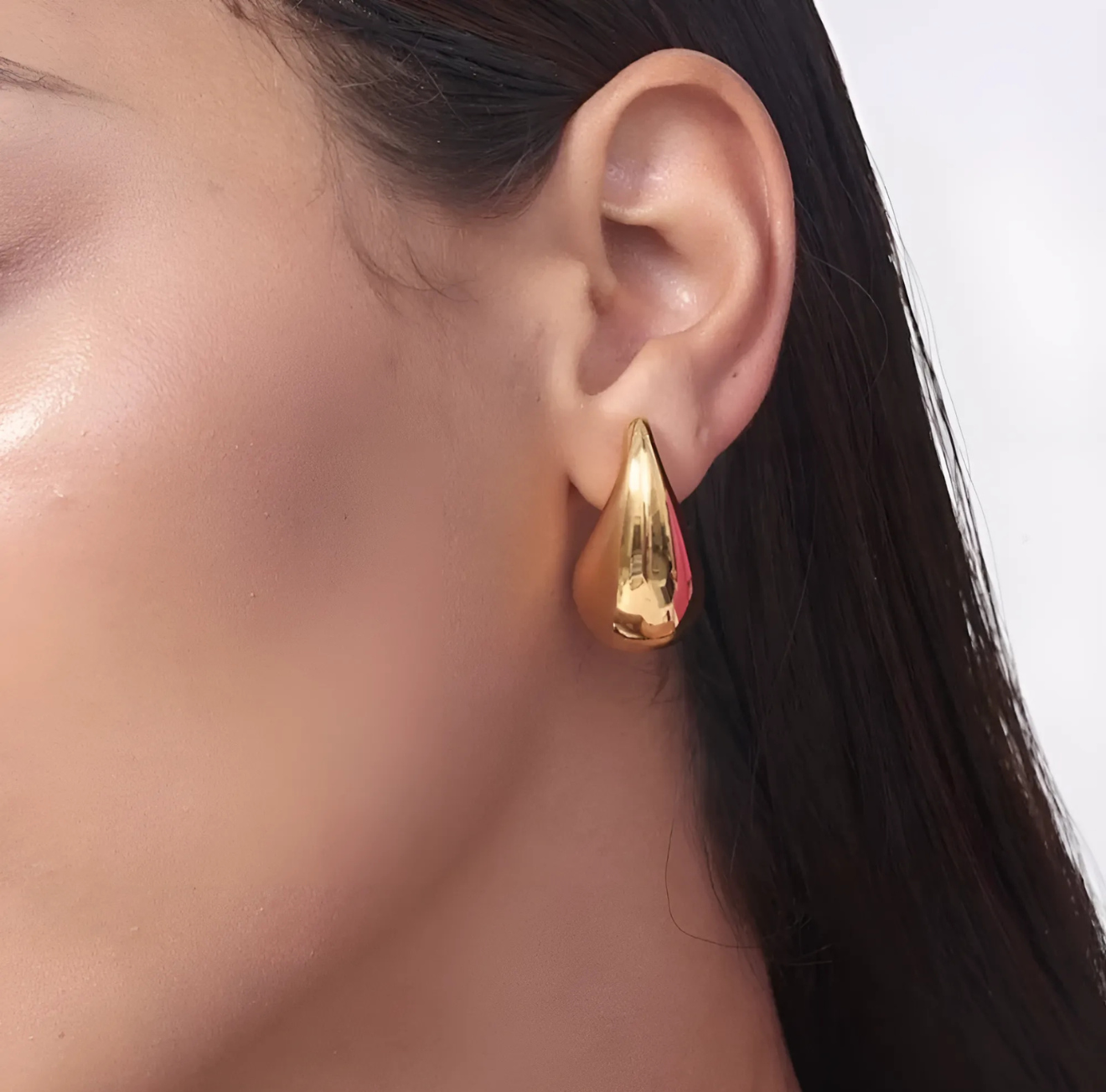 The Infinite Shop gold teardrop earrings shown on model with sleek hairstyle, featuring smooth polished finish for a modern minimalist style