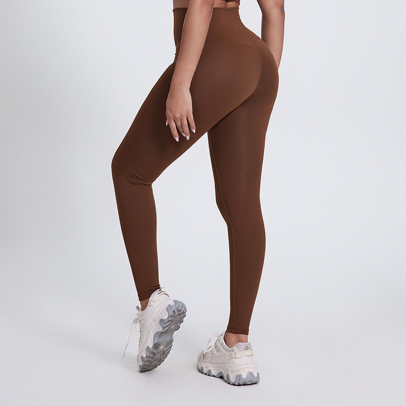 Brown V-Shaped High Waist Yoga Pants from The Infinite Shop shown from back view with white sneakers.